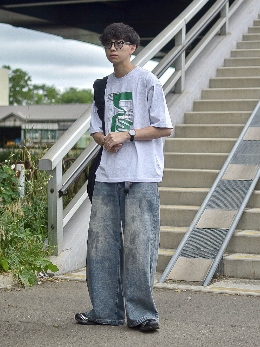 グレー系のTシャツ/カットソー、ブルー系のデニムパンツ、ブラック系のショルダーバッグを着用したメンズの夏コーディネートの3枚目の写真