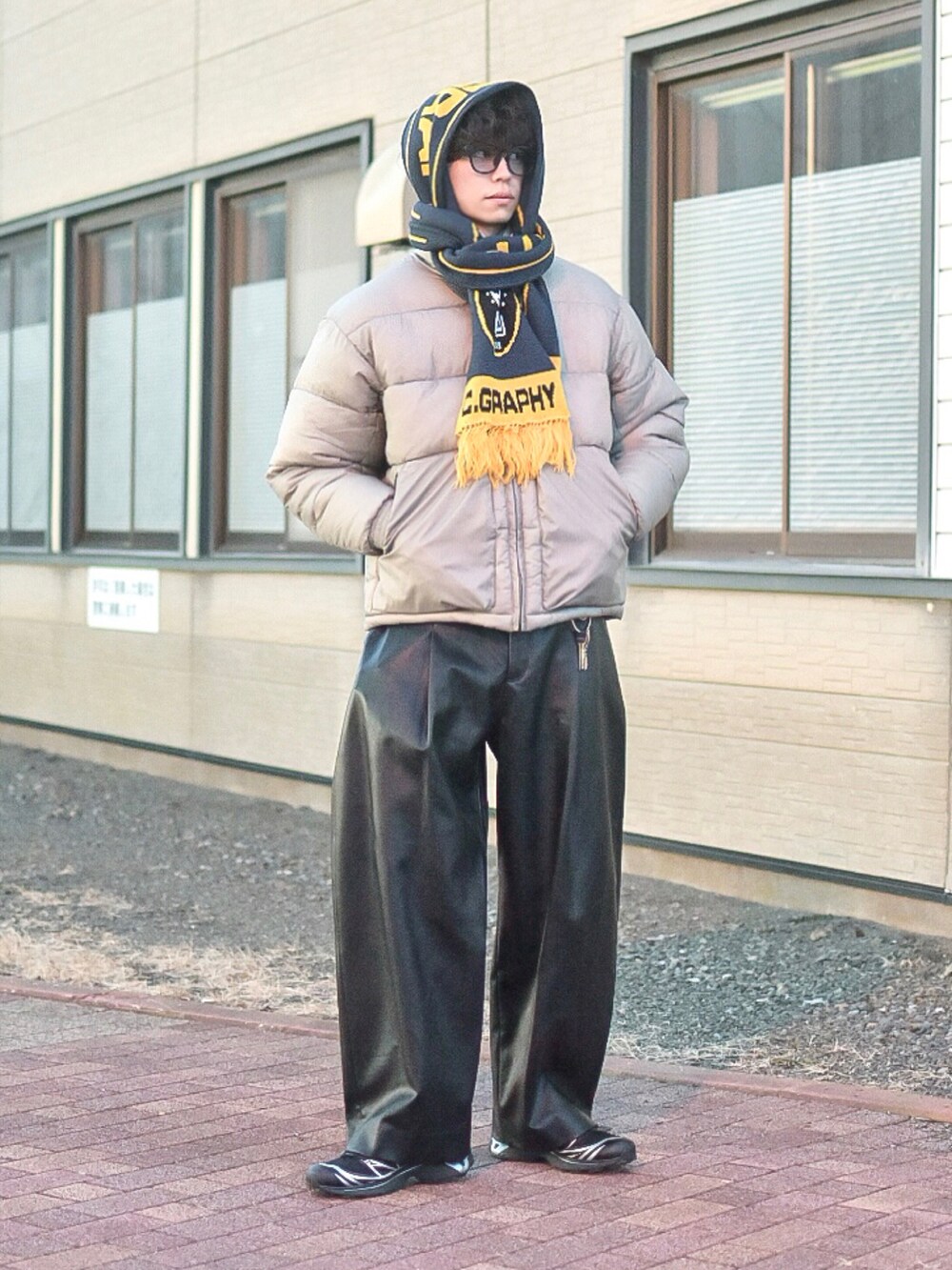 グレー系のダウンジャケット/コート、ブラック系のその他パンツ、ブラック系のスニーカーを着用したメンズの冬コーディネートの2枚目の写真