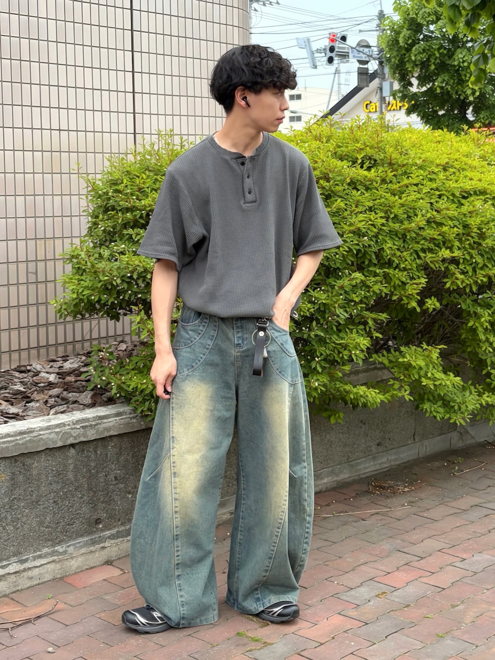 グレー系のTシャツ/カットソー、ブルー系のデニムパンツ、ブラック系のスニーカーを着用したメンズの夏コーディネートの2枚目の写真