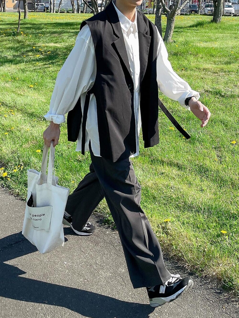 ブラック系のベスト、ホワイト系のシャツ/ブラウス、グレー系のスラックスを着用したメンズの春コーディネートの2枚目の写真