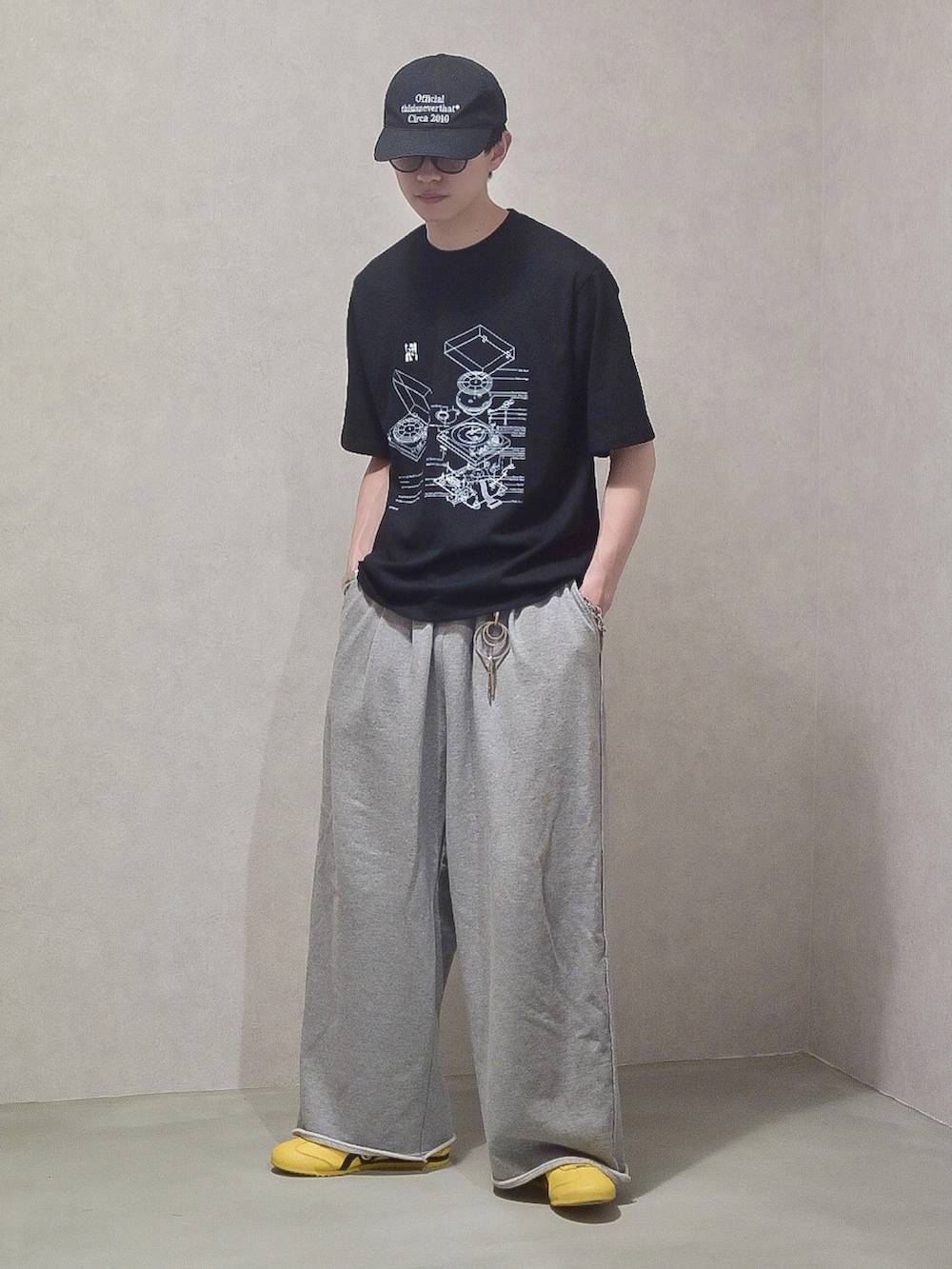 ブラック系のTシャツ/カットソー、グレー系のスウェットパンツ、イエロー系のスニーカーを着用したメンズの夏コーディネートの3枚目の写真