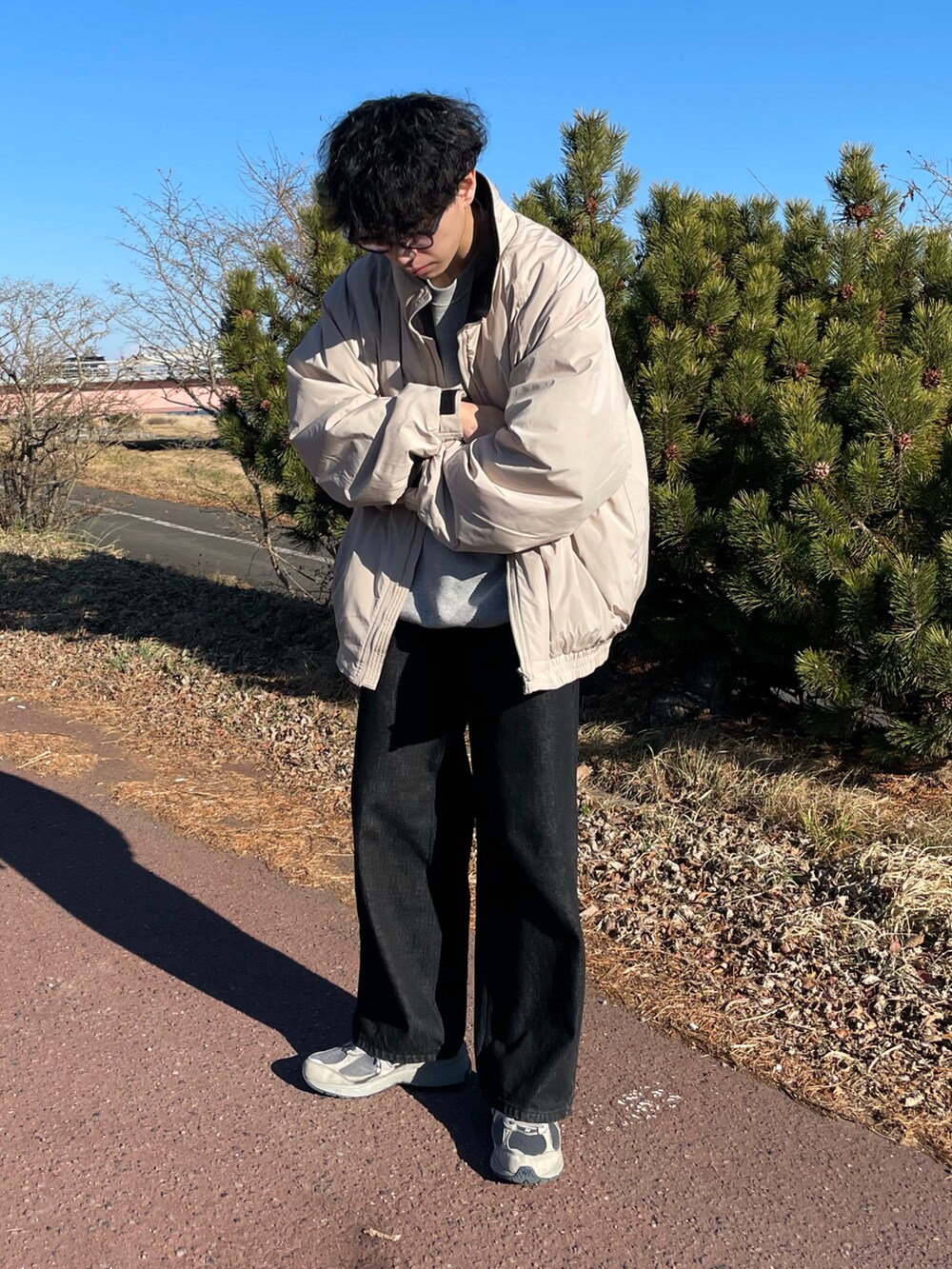 ベージュ系のジャケット/アウター、ブラック系のデニムパンツ、グレー系のスニーカーを着用したメンズの冬コーディネートの2枚目の写真