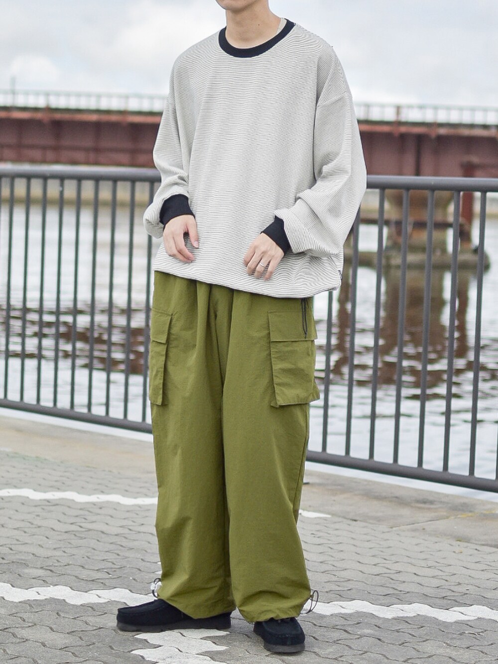 ブラック系のトップス、ブラック系のモカシン/デッキシューズ、グリーン系のカーゴパンツを着用したメンズの秋コーディネートの2枚目の写真