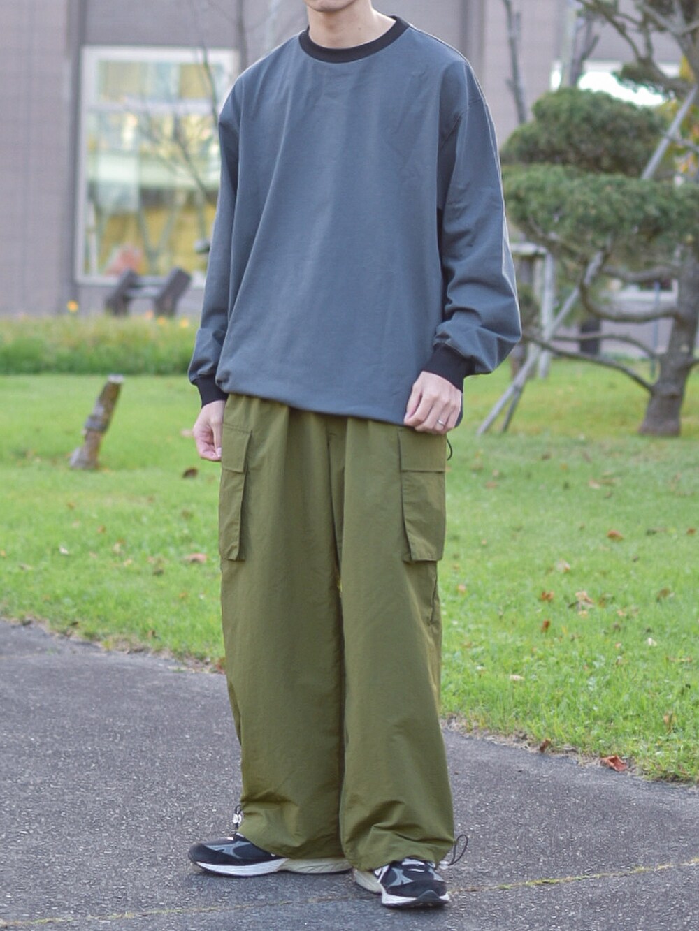 ブラック系のシューズ、グレー系のTシャツ/カットソー、グリーン系のカーゴパンツを着用したメンズの秋コーディネートの2枚目の写真