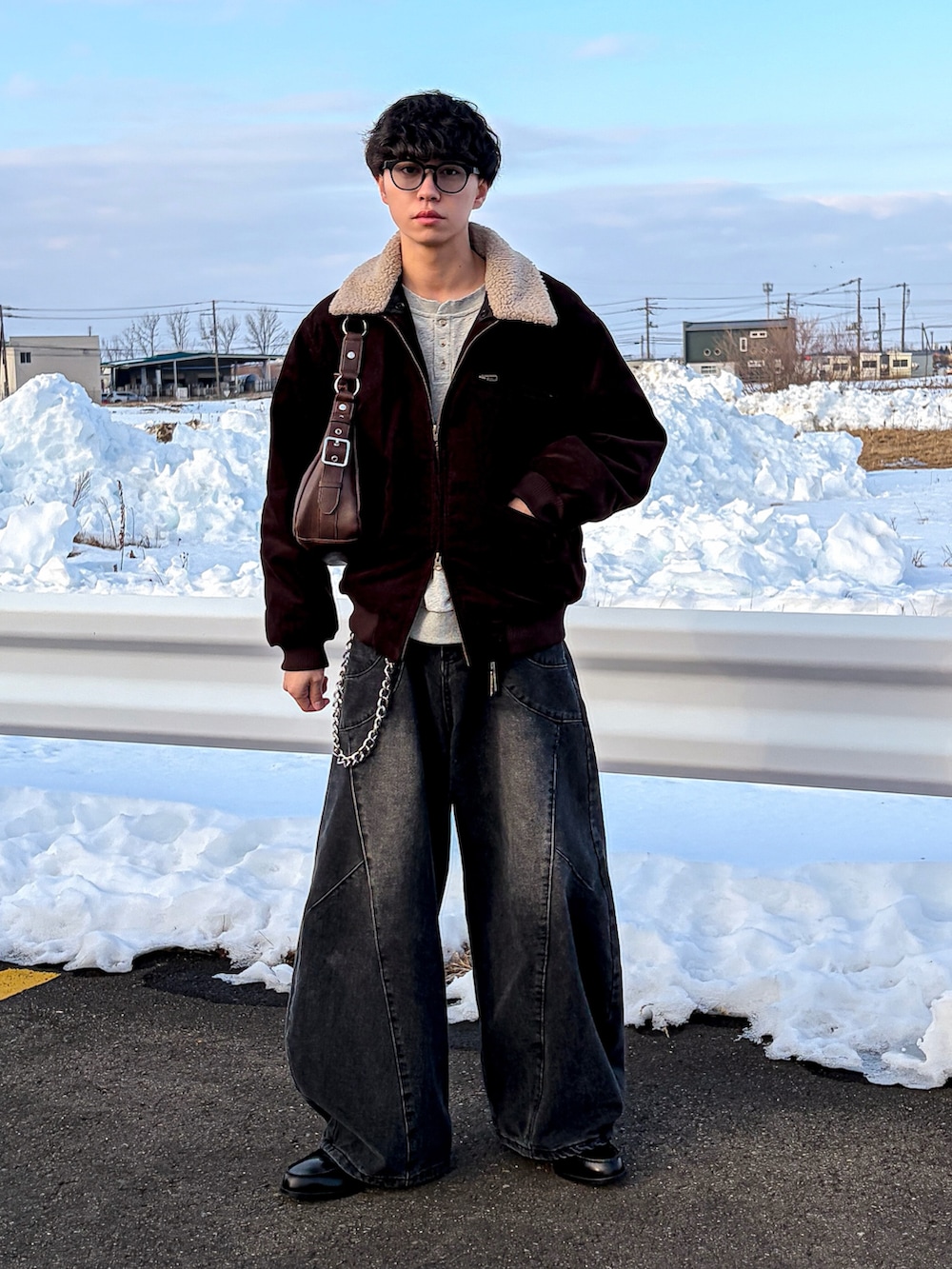 ブラウン系のブルゾン、グレー系のスウェット、ブラック系のデニムパンツを着用したメンズの冬コーディネートの4枚目の写真