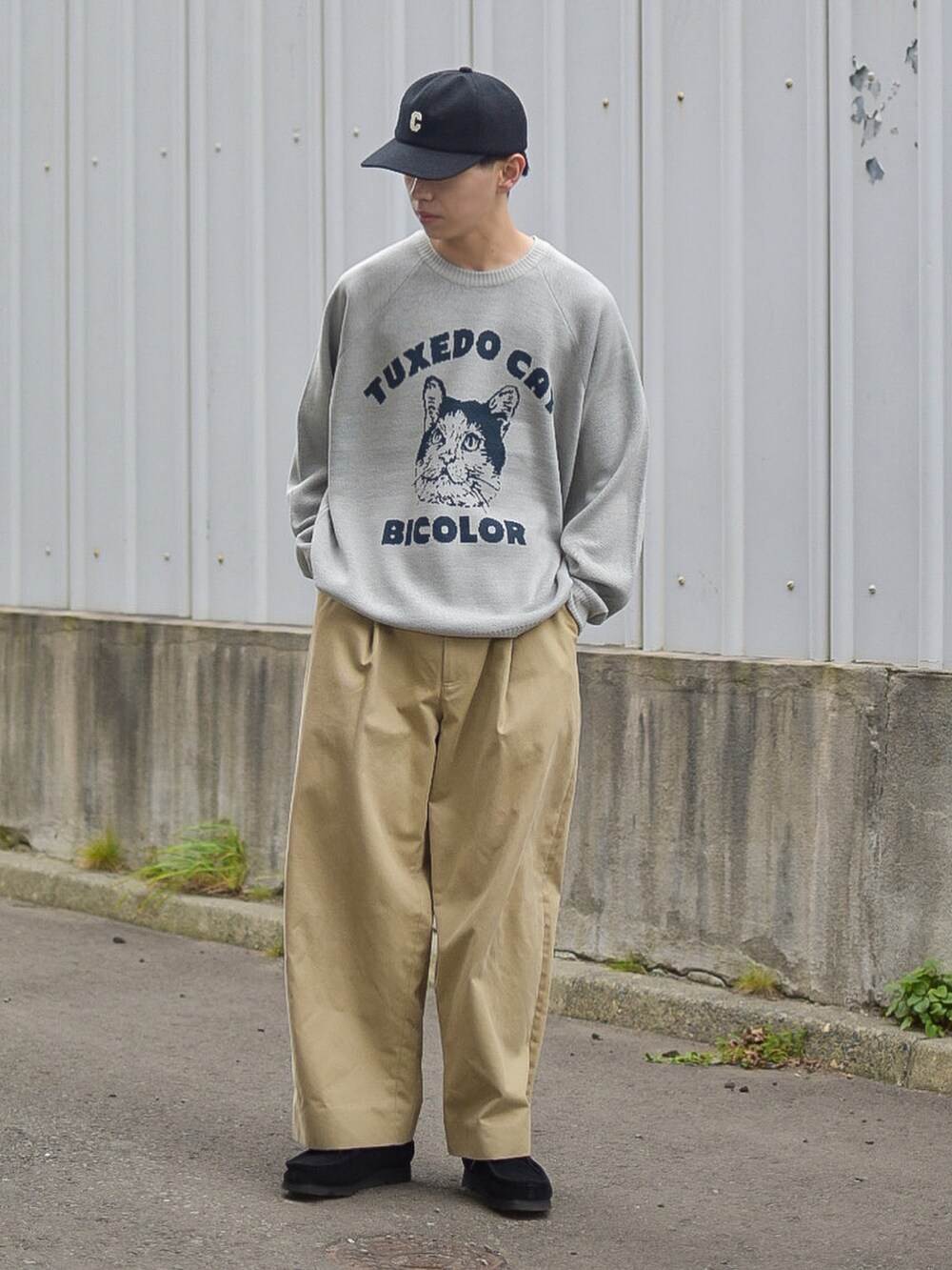 グレー系のニット/セーター、ベージュ系のその他パンツ、ブラック系のキャップを着用したメンズの秋コーディネートの3枚目の写真