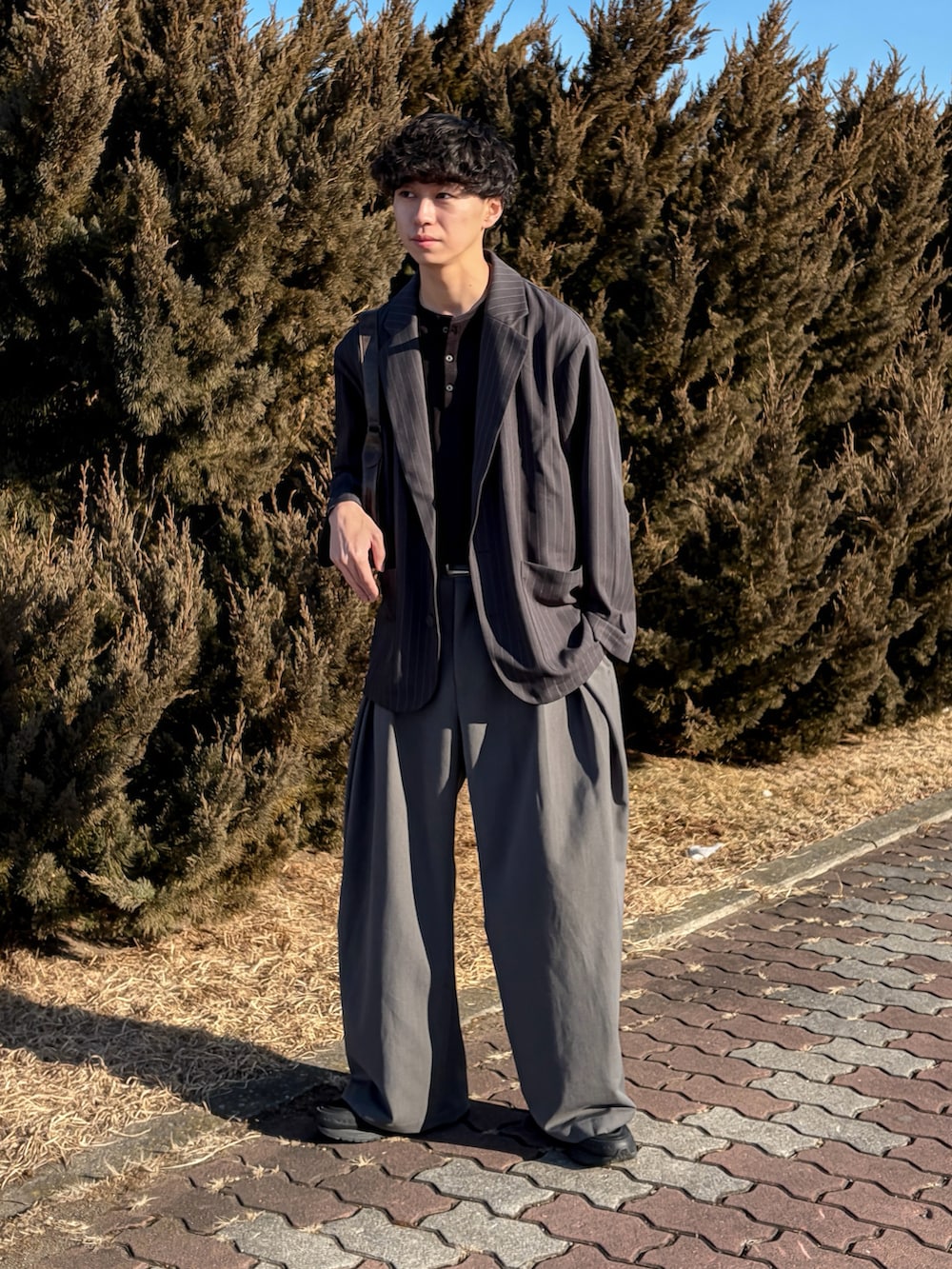 ブラック系のTシャツ/カットソー、グレー系のスラックス、ブラック系のシューズを着用したメンズの冬コーディネートの3枚目の写真