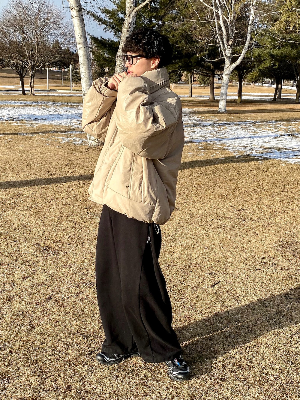 グリーン系のダウンジャケット/コート、ブラック系のスウェットパンツ、ブラック系のスニーカーを着用したメンズの冬コーディネートの2枚目の写真