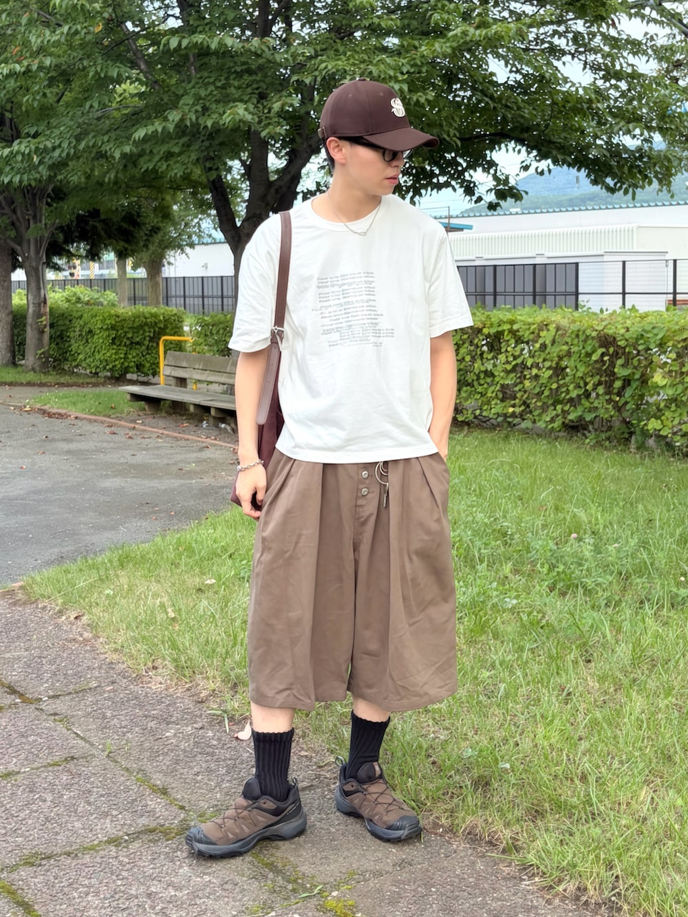 ホワイト系のTシャツ/カットソー、グリーン系のその他パンツ、ブラウン系のショルダーバッグを着用したメンズの夏コーディネートの2枚目の写真