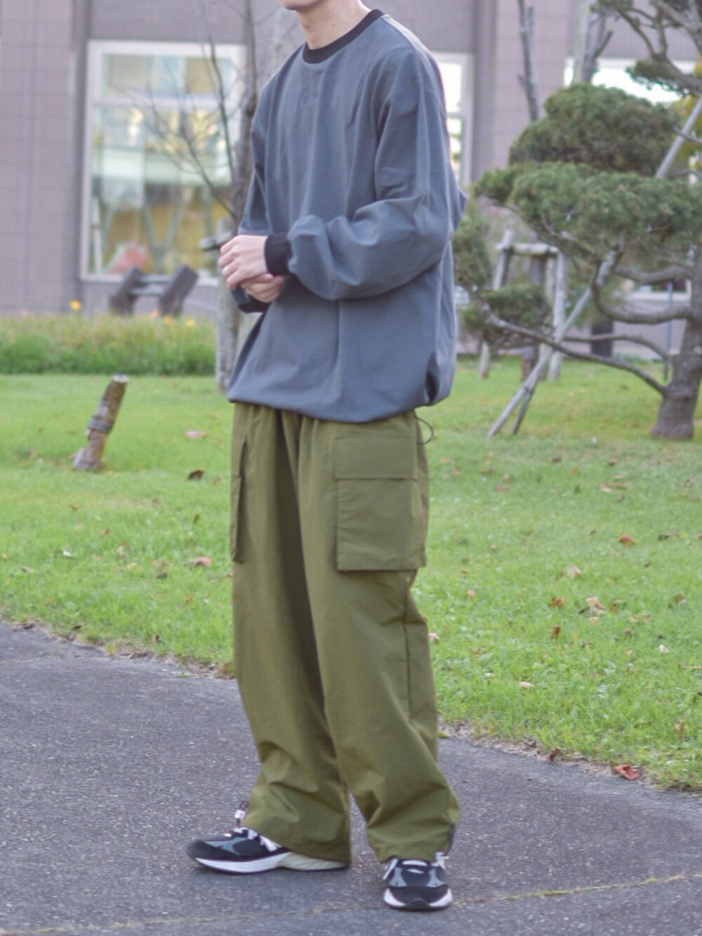 ブラック系のシューズ、グレー系のTシャツ/カットソー、グリーン系のカーゴパンツを着用したメンズの秋コーディネートの3枚目の写真