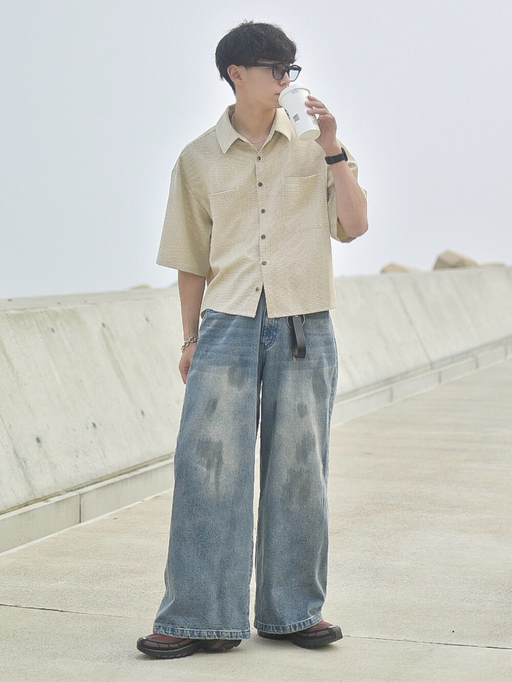 ベージュ系のシャツ/ブラウス、ブルー系のデニムパンツ、ブラウン系のスニーカーを着用したメンズの夏コーディネートの2枚目の写真