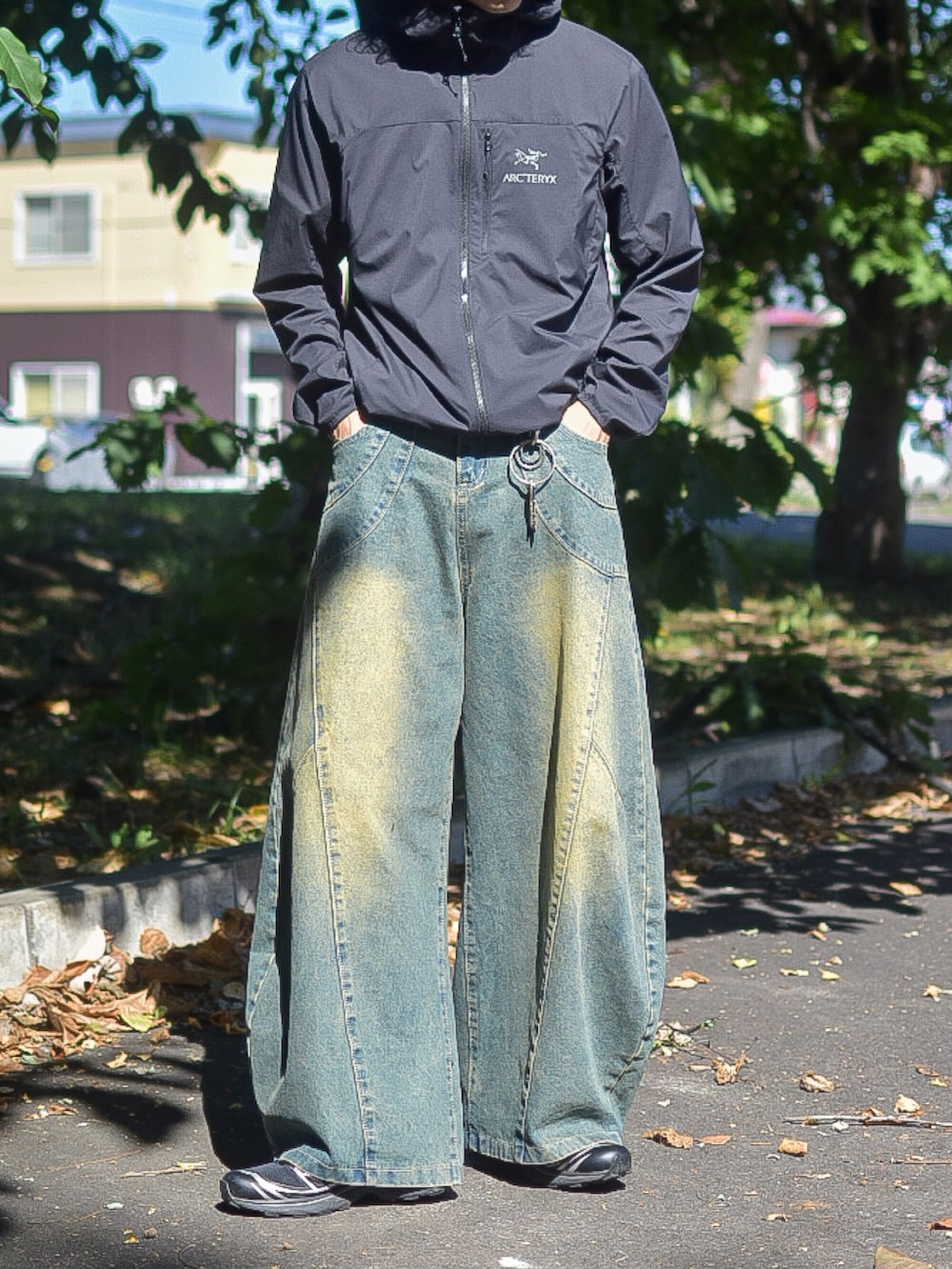 ブラック系のブルゾン、ブルー系のデニムパンツ、ブラック系のスニーカーを着用したメンズの秋コーディネートの3枚目の写真
