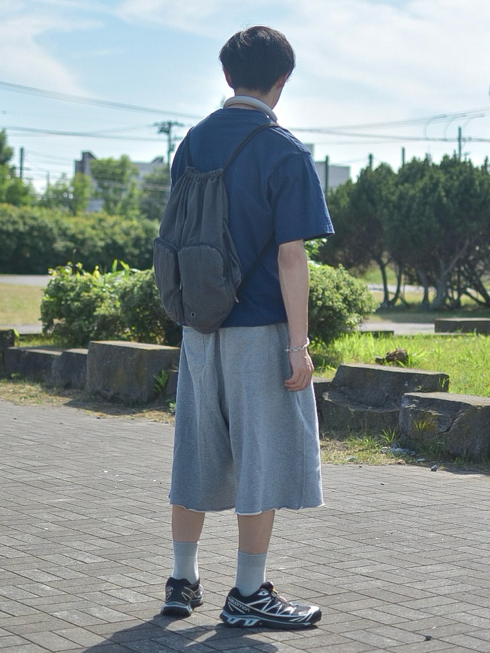 ブルー系のTシャツ/カットソー、グレー系のスウェットパンツ、グレー系のバックパック/リュックを着用したメンズの夏コーディネートの3枚目の写真
