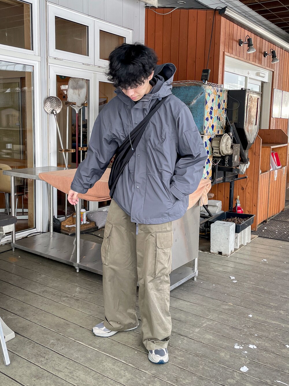 グレー系のマウンテンパーカー、グリーン系のカーゴパンツ、グレー系のスニーカーを着用したメンズの冬コーディネートの4枚目の写真
