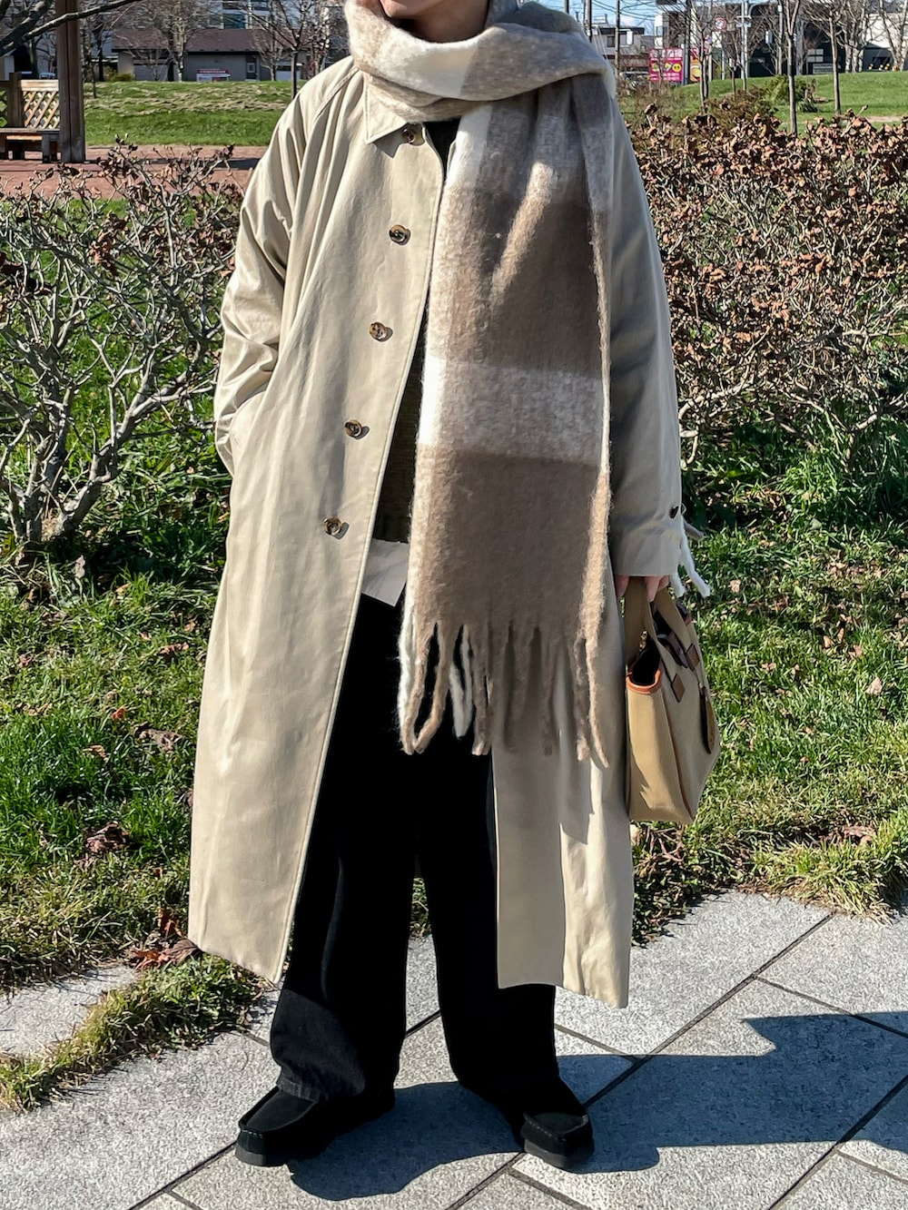 グリーン系のニット/セーター、ブラック系のデニムパンツ、ブラック系のモカシン/デッキシューズを着用したメンズの秋コーディネートの3枚目の写真