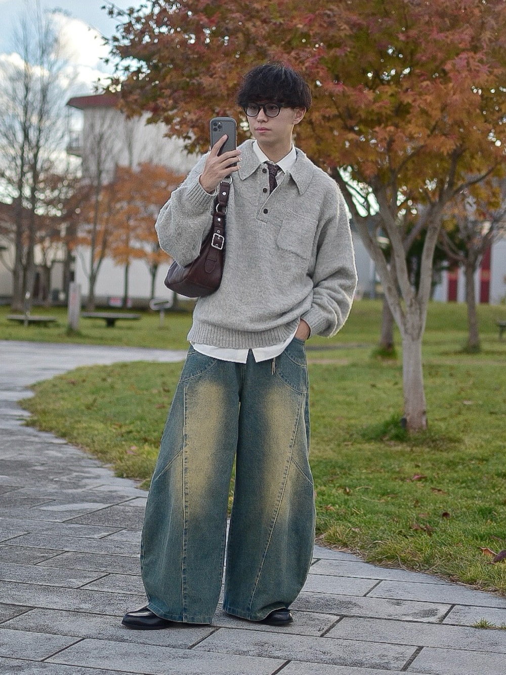 グレー系のポロシャツ、ホワイト系のシャツ/ブラウス、ブルー系のデニムパンツを着用したメンズの秋コーディネートの2枚目の写真