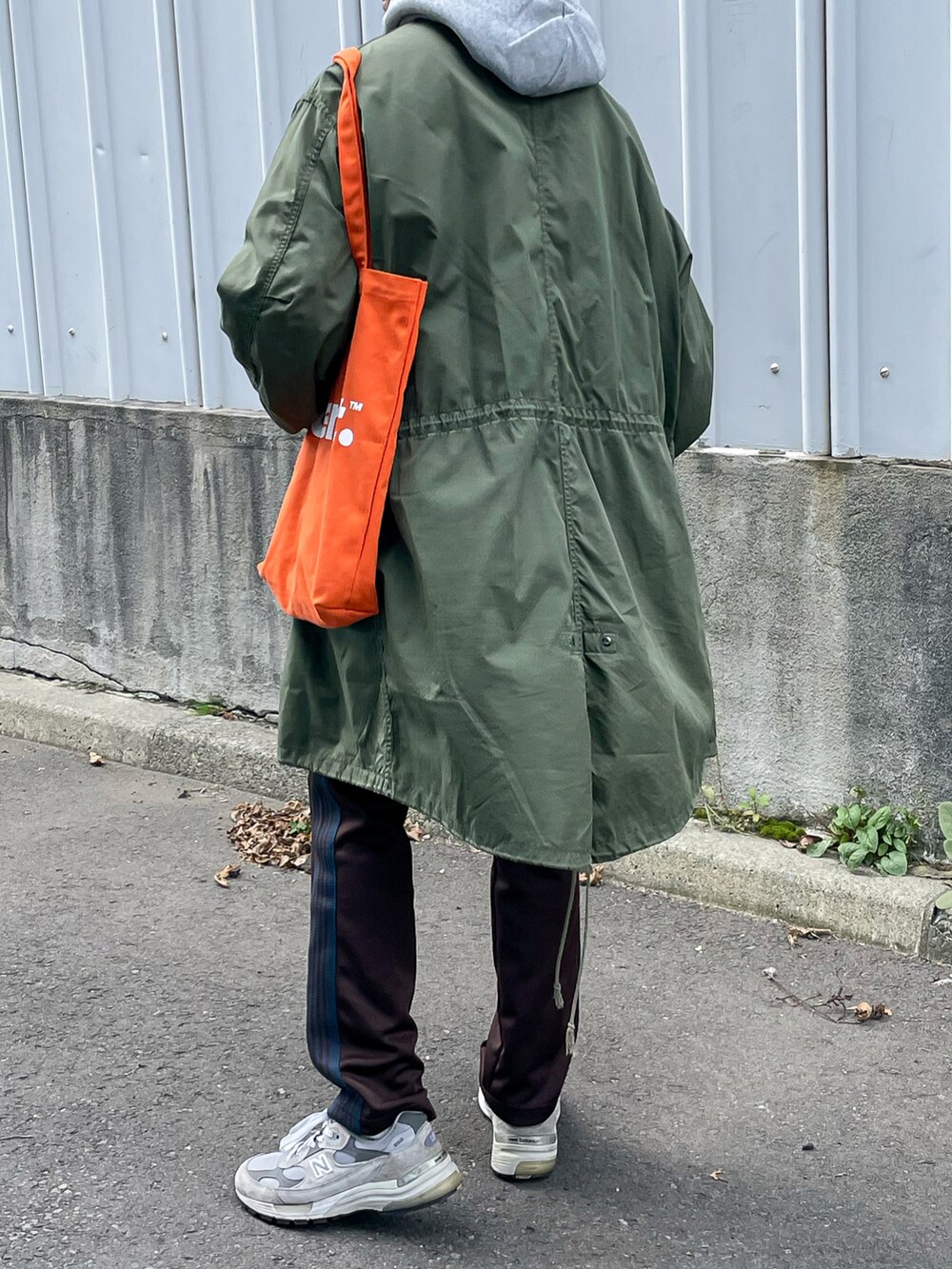 ブラウン系のパンツ、オレンジ系のトートバッグを着用したメンズの秋コーディネートの4枚目の写真