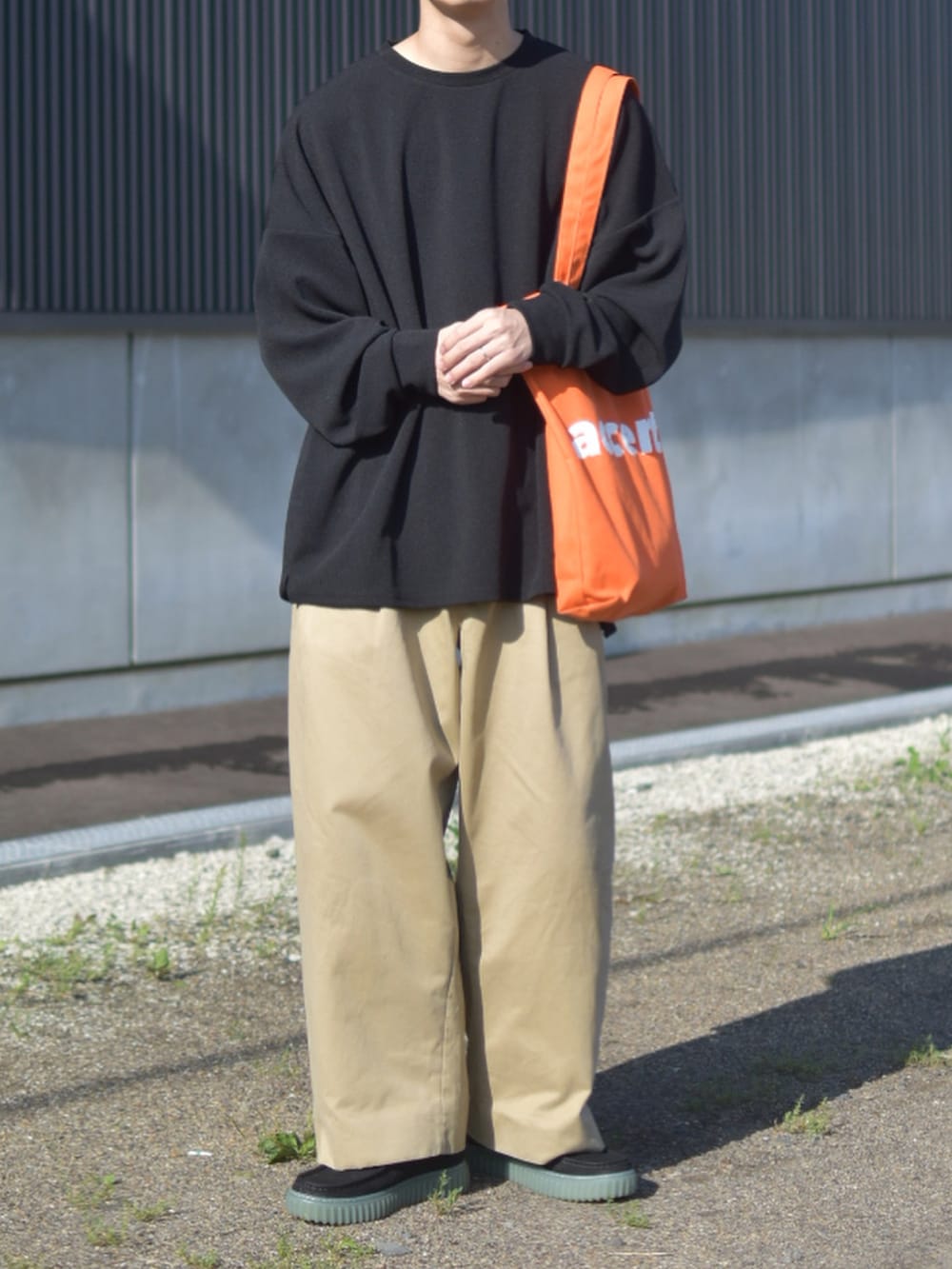 ブラック系のTシャツ/カットソー、ベージュ系のその他パンツ、ブラック系のモカシン/デッキシューズを着用したメンズの秋コーディネートの2枚目の写真
