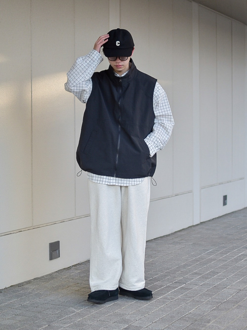 ブラック系のベスト、ホワイト系のシャツ/ブラウス、ホワイト系のスウェットパンツを着用したメンズの冬コーディネートの3枚目の写真