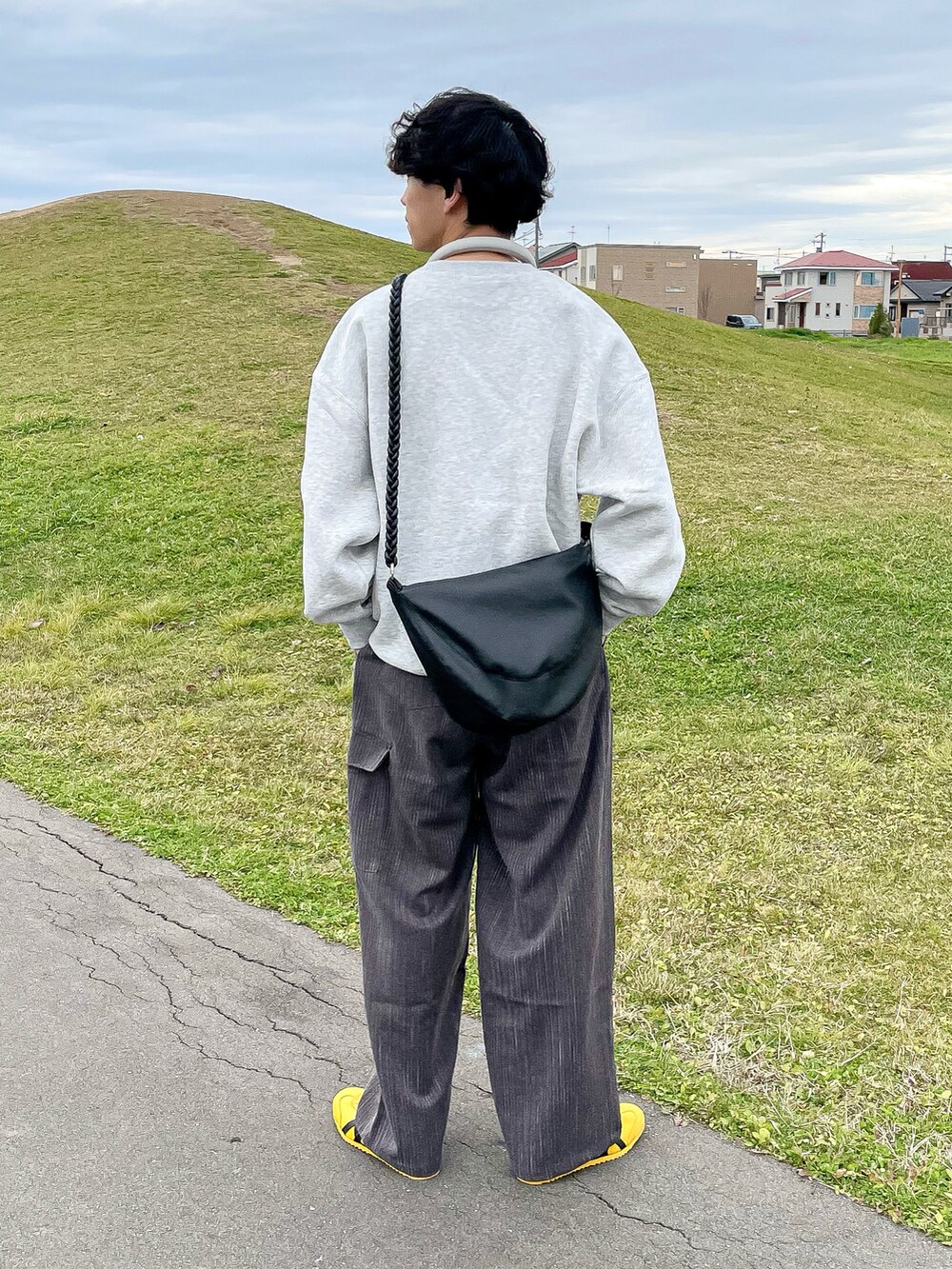 グレー系のスウェット、ブラウン系のその他パンツ、イエロー系のスニーカーを着用したメンズの秋コーディネートの5枚目の写真