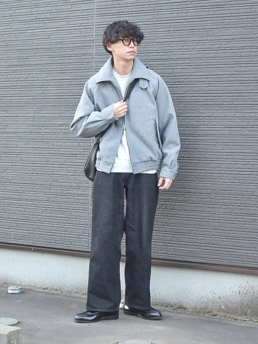 グレー系のブルゾン、グレー系のスウェット、ブラック系のデニムパンツを着用したメンズの冬コーディネートの2枚目の写真