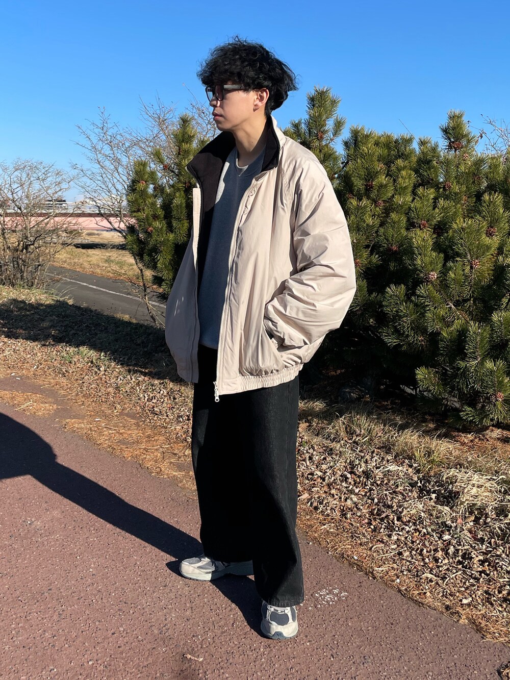 ベージュ系のジャケット/アウター、ブラック系のデニムパンツ、グレー系のスニーカーを着用したメンズの冬コーディネートの3枚目の写真