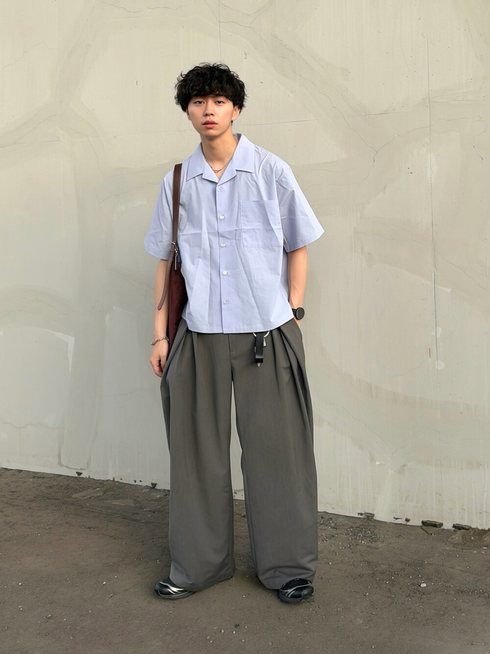ブルー系のシャツ/ブラウス、グレー系のスラックス、ブラック系のスニーカーを着用したメンズの夏コーディネートの2枚目の写真
