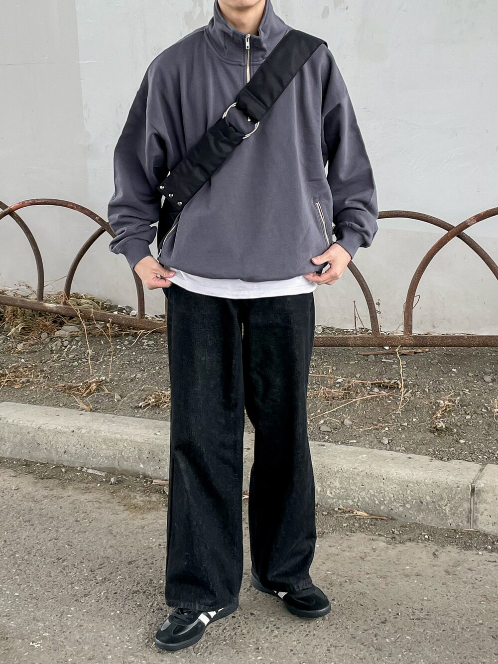 グレー系のスウェット、ブラック系のデニムパンツ、ブラック系のショルダーバッグを着用したメンズの冬コーディネートの5枚目の写真