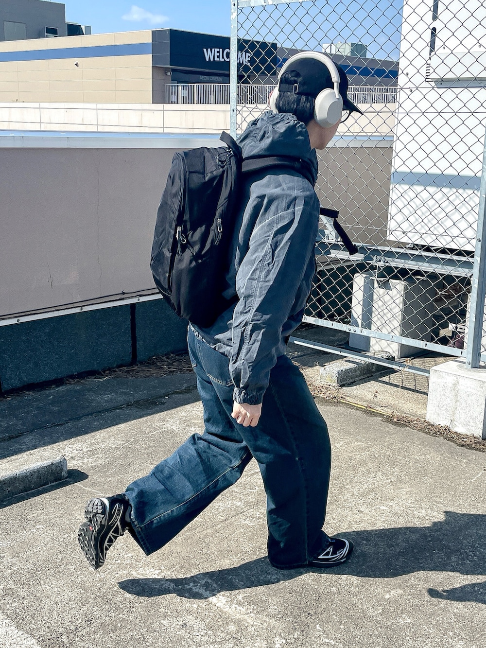 グレー系のマウンテンパーカー、ブルー系のデニムパンツ、ブラック系のスニーカーを着用したメンズの春コーディネートの4枚目の写真