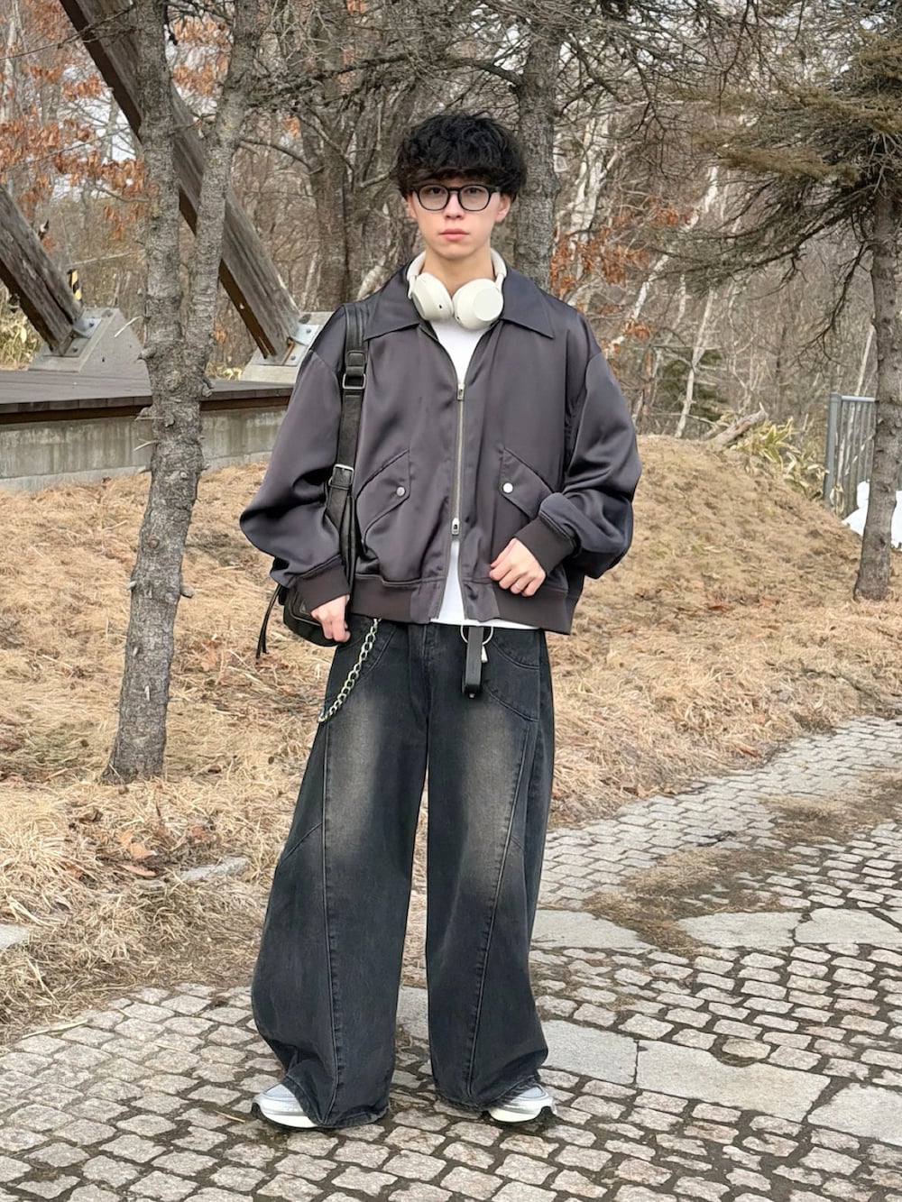 グレー系のMA-1、ホワイト系のTシャツ/カットソー、ブラック系のデニムパンツを着用したメンズの冬コーディネートの2枚目の写真