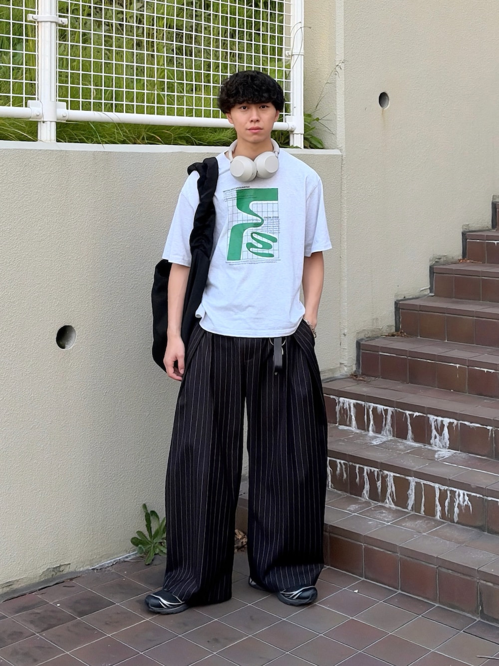 グレー系のTシャツ/カットソー、ブラック系のスラックス、ブラック系のショルダーバッグを着用したメンズの夏コーディネートの2枚目の写真