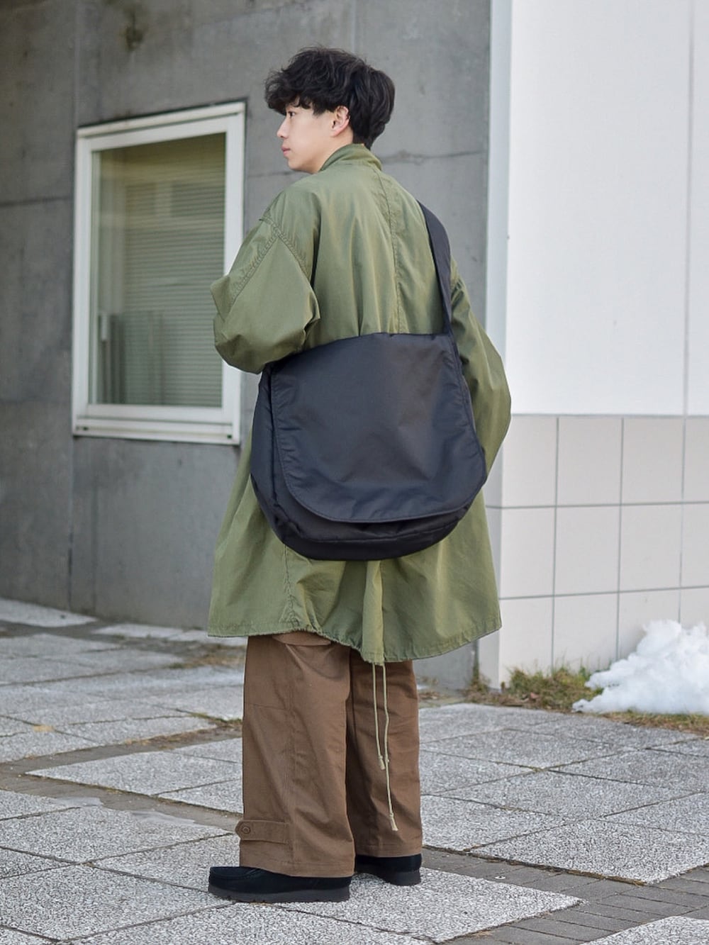 グリーン系のモッズコート、ブルー系のスウェット、ブラウン系のカーゴパンツを着用したメンズの冬コーディネートの3枚目の写真