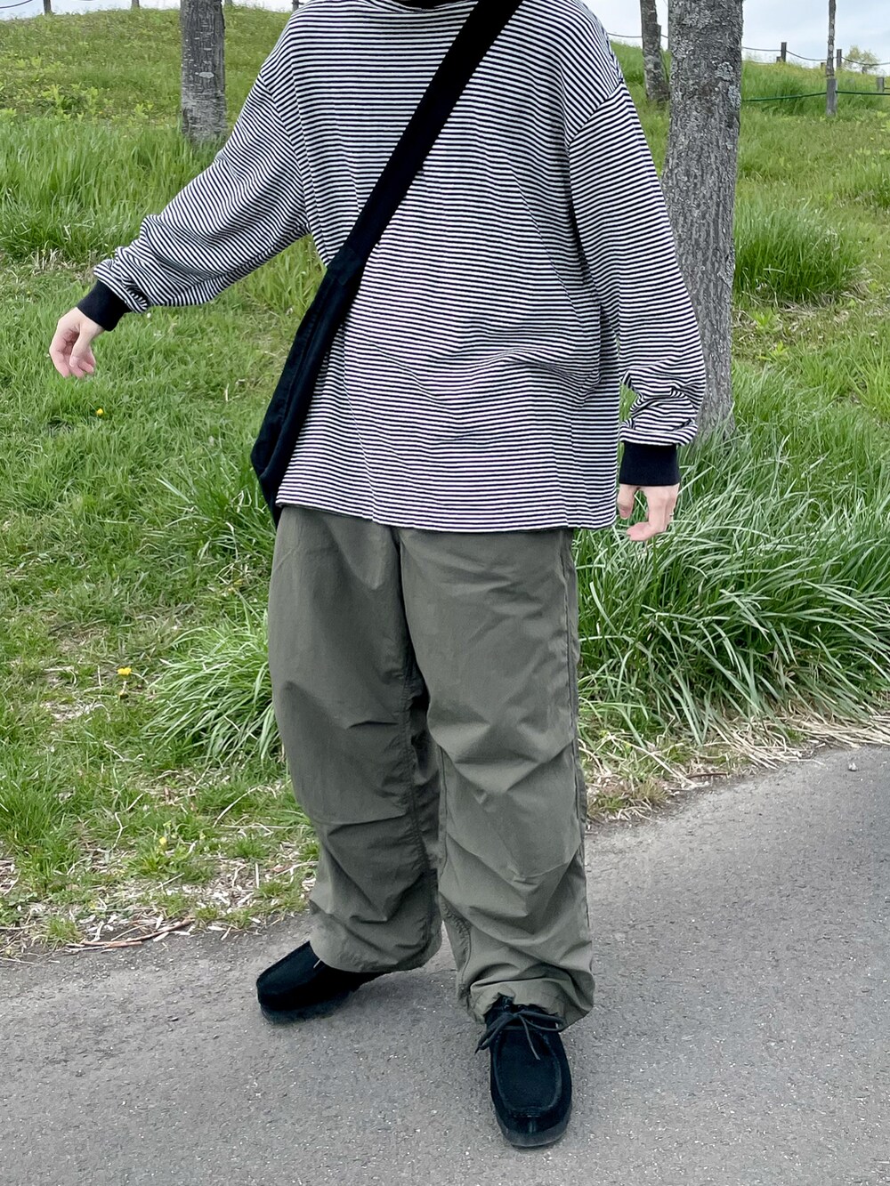 ブラック系のTシャツ/カットソー、グリーン系のパンツを着用したメンズの春コーディネートの2枚目の写真