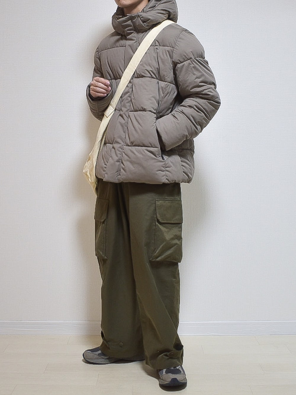 ベージュ系のブルゾン、グリーン系のカーゴパンツを着用したメンズの秋コーディネートの2枚目の写真