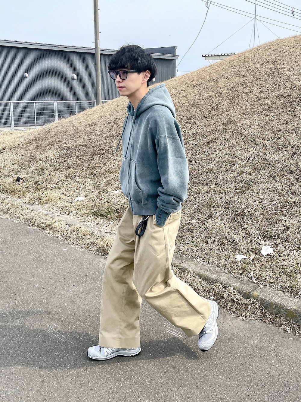 グレー系のパーカー、ベージュ系のその他パンツ、グレー系のスニーカーを着用したメンズの春コーディネートの5枚目の写真