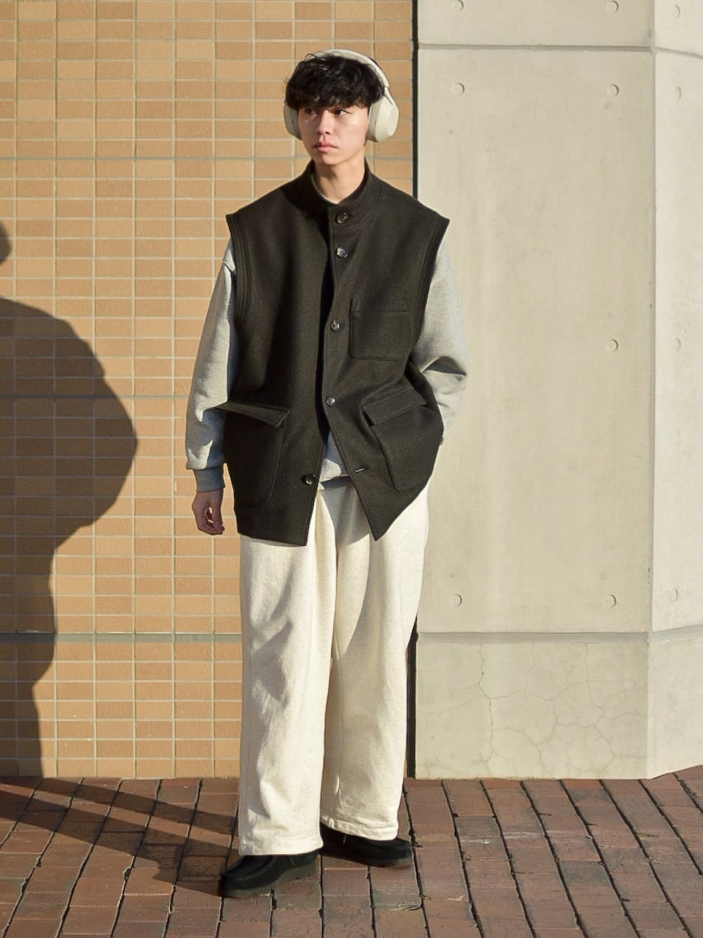 グレー系のスウェット、ホワイト系のスウェットパンツ、ブラック系のモカシン/デッキシューズを着用したメンズの冬コーディネートの2枚目の写真