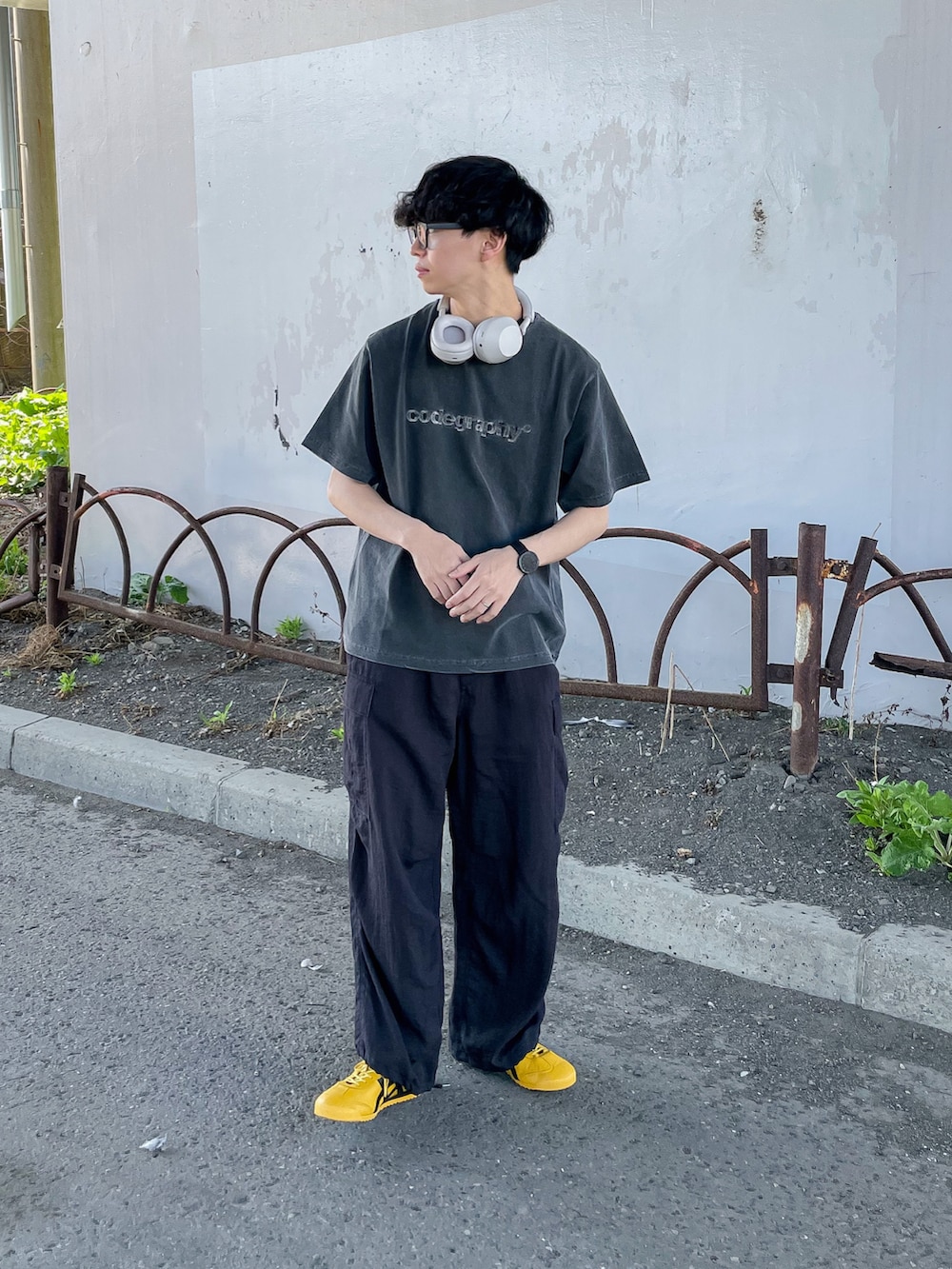 ブラック系のTシャツ/カットソー、ブラック系のカーゴパンツ、イエロー系のスニーカーを着用したメンズの春コーディネートの3枚目の写真