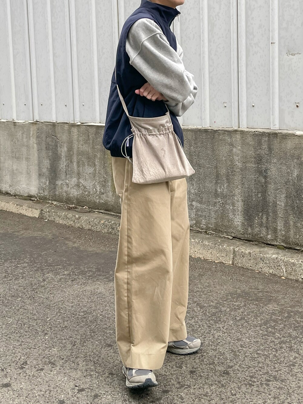 ブルー系のベスト、ベージュ系のその他パンツ、グレー系のスニーカーを着用したメンズの春コーディネートの3枚目の写真