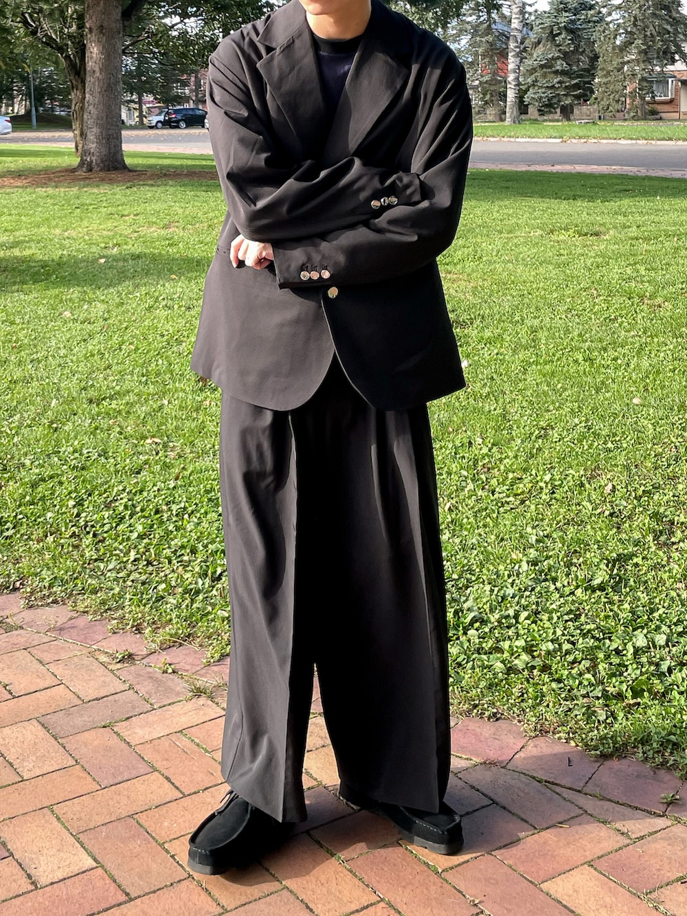 ブラック系のテーラードジャケット、ブラック系のその他パンツ、ブラック系のモカシン/デッキシューズを着用したメンズの秋コーディネートの5枚目の写真