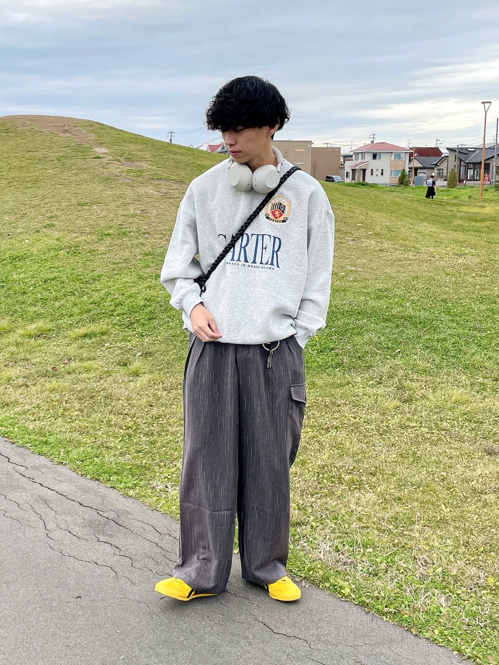 グレー系のスウェット、ブラウン系のその他パンツ、イエロー系のスニーカーを着用したメンズの秋コーディネートの2枚目の写真