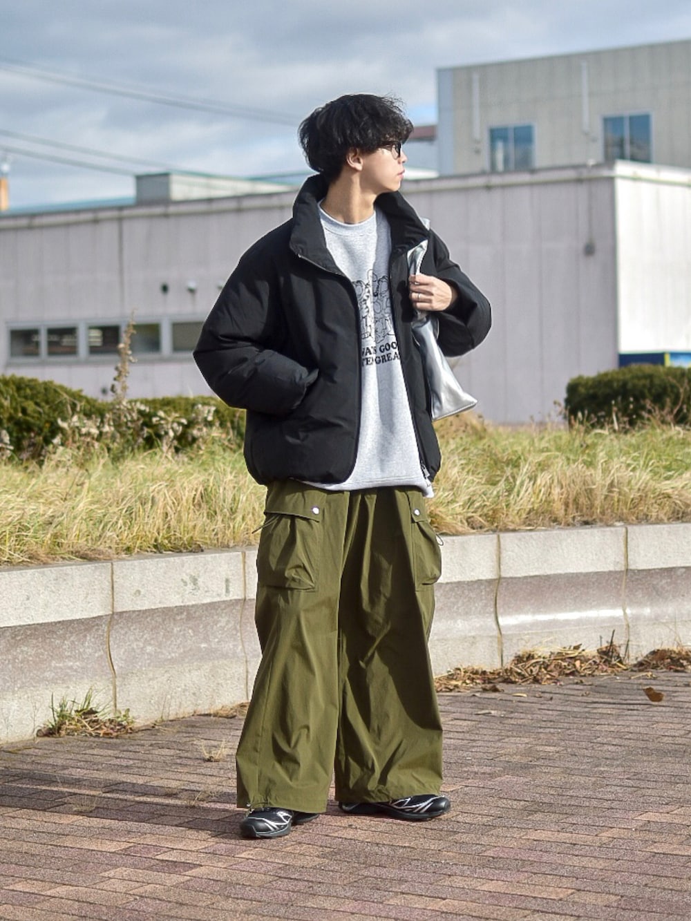 ブラック系のダウンジャケット/コート、グレー系のスウェット、グリーン系のカーゴパンツを着用したメンズの冬コーディネートの2枚目の写真