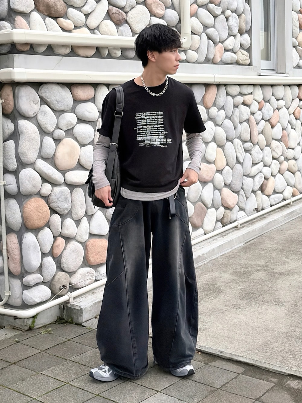 グレー系のスニーカー、ブラック系のTシャツ/カットソー、ブラック系のデニムパンツを着用したメンズの夏コーディネートの2枚目の写真
