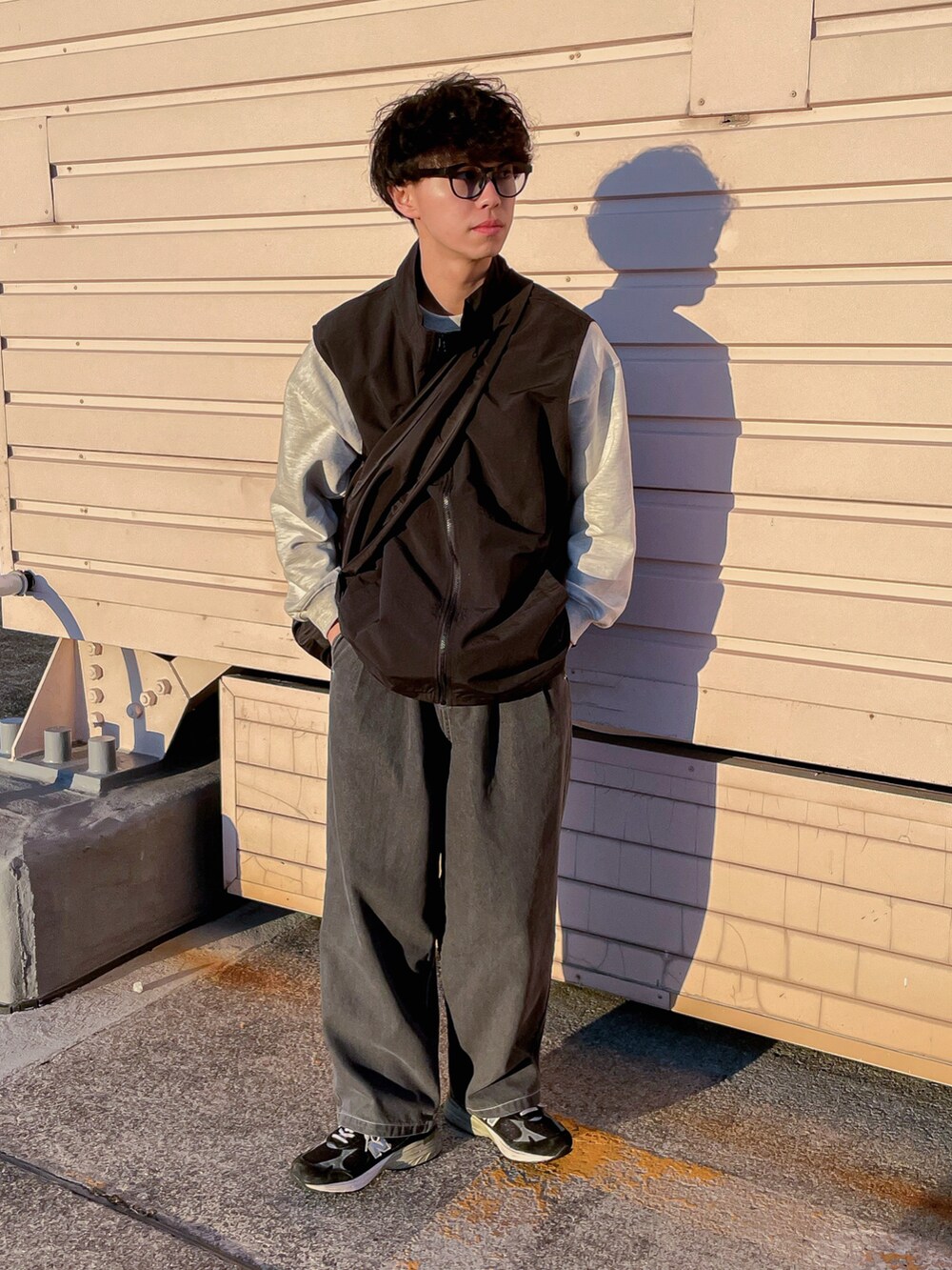 ブラック系のベスト、グレー系のスウェット、グレー系のデニムパンツを着用したメンズの冬コーディネートの2枚目の写真