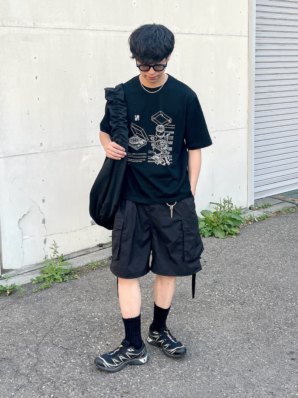 ブラック系のTシャツ/カットソー、ブラック系のスニーカー、ブラック系のショルダーバッグを着用したメンズの夏コーディネートの2枚目の写真