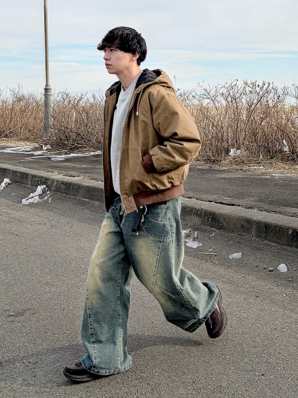 ブラウン系のその他アウター、ブルー系のデニムパンツ、グレー系のスウェットを着用したメンズの冬コーディネートの5枚目の写真