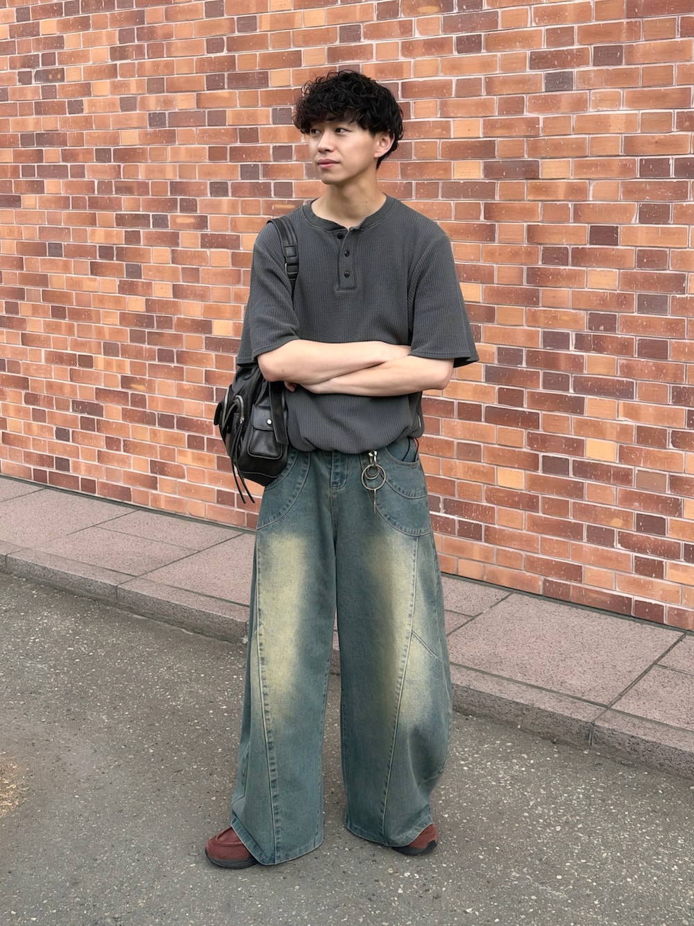 ブラック系のショルダーバッグ、グレー系のTシャツ/カットソー、ブルー系のデニムパンツを着用したメンズの夏コーディネートの2枚目の写真
