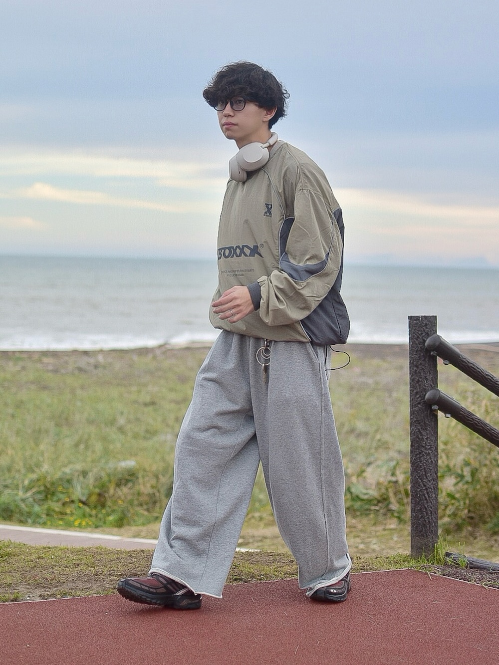 グリーン系のスウェット、グレー系のスウェットパンツ、ブラウン系のスニーカーを着用したメンズの秋コーディネートの4枚目の写真