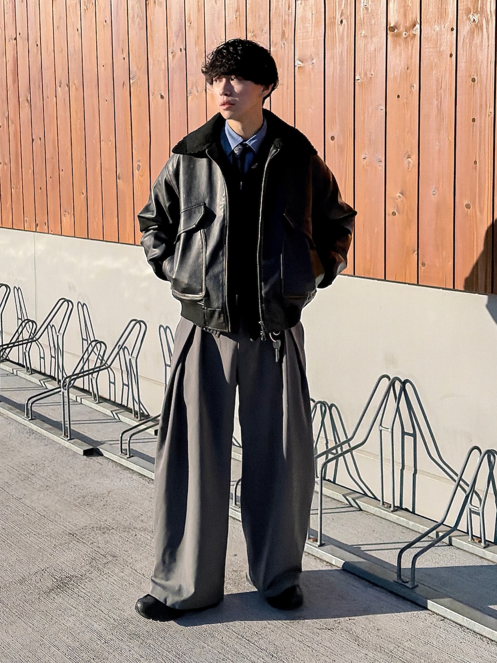 ブラック系のニット/セーター、ブルー系のシャツ/ブラウス、ブラック系のブルゾンを着用したメンズの冬コーディネートの2枚目の写真