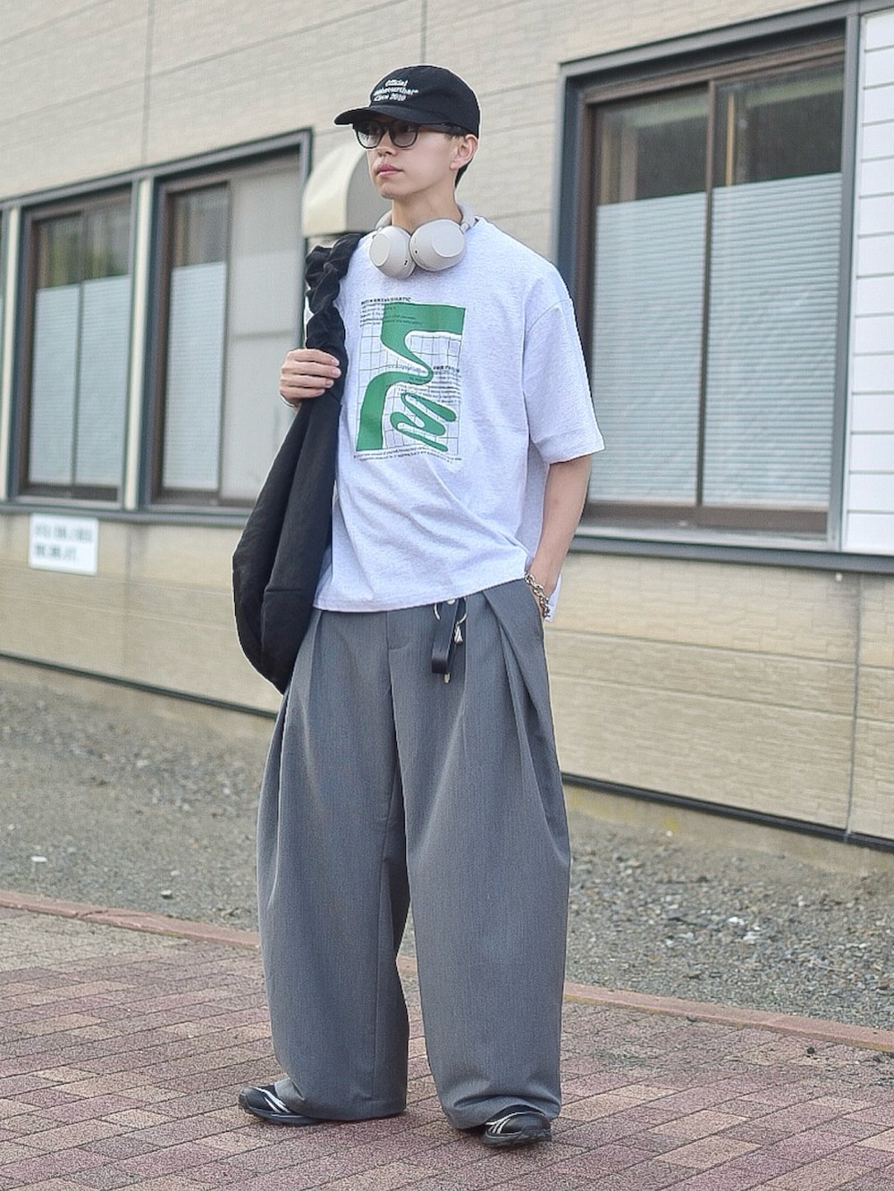 グレー系のTシャツ/カットソー、グレー系のスラックス、ブラック系のスニーカーを着用したメンズの夏コーディネートの5枚目の写真