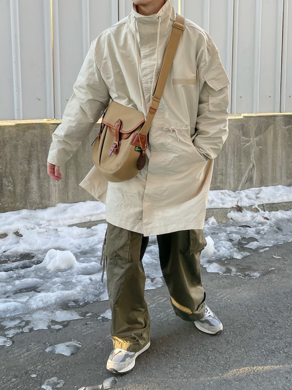 ホワイト系のモッズコートを着用したメンズの冬コーディネートの2枚目の写真